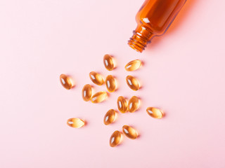 Fish oil capsules (omega-3) on a pink background