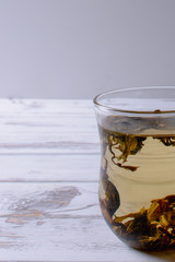 cup with green tea and teapot on white wooden table background. over light