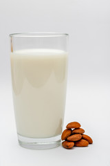 glass of almond milk on white background