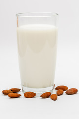 glass of almond milk on white background