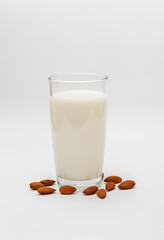 glass of almond milk on white background