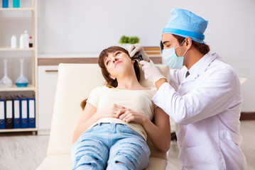 Young woman visting male doctor otolaryngologist