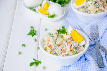 Russian traditional salad Olivier with vegetables and meat