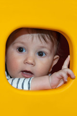 Baby boy is posing through a plastic window