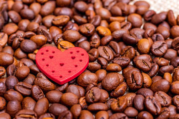 Red heart among coffee beans. The background of coffee beans. I love coffee_