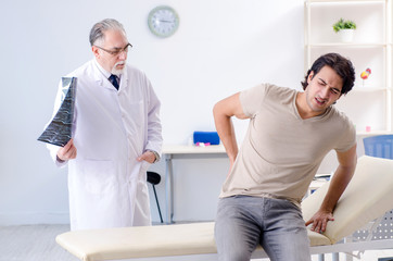 Fototapeta premium Young man visiting old male doctor radiologist 