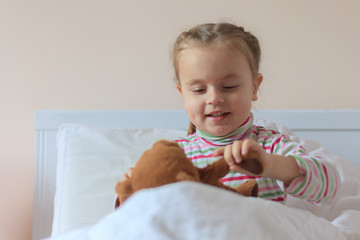 Naklejka premium Little girl holding teddy bear