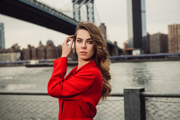 Fototapeta premium Beautiful fashion model woman posting in New York City wearing red jacket