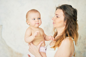 beautiful young mother with a baby in her arms is standing The concept of a happy family, motherhood