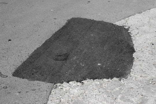 New and old asphalt surface patch city street pavement