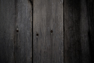 Old dark grey wood texture for background. Wooden boards with knots, scratches and rusty nails