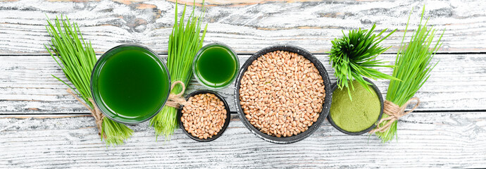 Green wheat juice on a white background. Top view. Free space for your text.