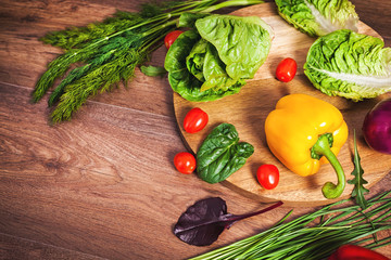 Different raw vegetables on a brown wooden background