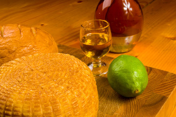 national Adyghe cheese homemade on a cutting Board with a knife, Basil, parsley, lime, sesame oil,...