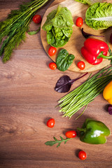 Different raw vegetables on a brown wooden background