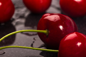 large ripe red sweet cherries in a black dish, close-up