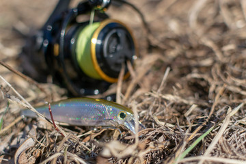 Fishing lures and spinning tackle on the grass. Fishing in the spring.