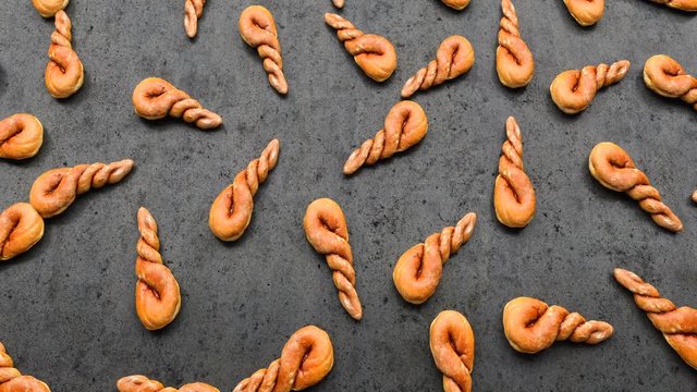 camera moves over a set of twisted buns spread out on a black table