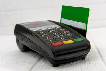 Banking terminal with credit card on wooden background