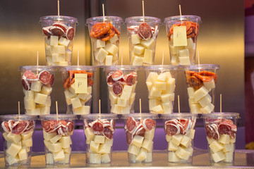  Containers with typical charcuterie products from Spain, contain fuet, cheese and chorizo.