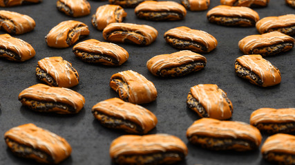 lot of appetizing buns with chocolate lying on the black close-up, 3D illustration