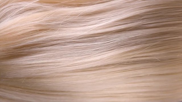 Hair. Beautiful healthy long straight blonde hair close-up texture. Dyed Wavy white blond hair background, coloring, extensions, cure, treatment concept. Haircare. Slow motion 4K UHD video