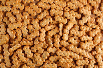 Fototapeta premium Composition of crackers with poppy seeds, spread out on a wooden background