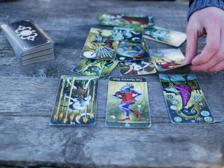 Polonne / Ukraine - 5 March 2019: A man spreads a pack of tarot cards. Future reading concept