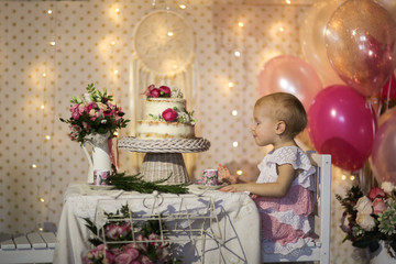 cake with fresh flowers on table and girl in dress