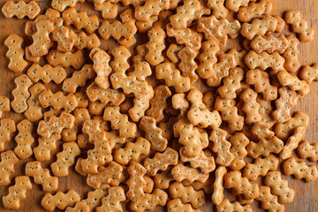 Composition of crackers with poppy seeds, spread out on a wooden background