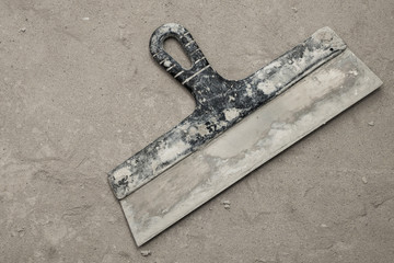 Spatulas with the remaining mortar. Gastarbeiter or guest worker concept. Tools for repair. Copy...