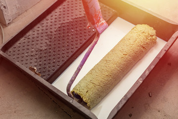Paint roller, with white primer. Room renovation concept