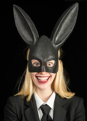 Happy easter. Bunny ears concept. Sexy woman wearing a black Easter Bunny. Beautiful young woman with bunny ears and blank poster on black background isolated.