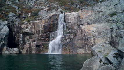 Waterfall in nature with wet rocks and stones