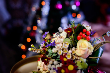 Pair of wedding rings lying on a colorful bouquet with different flowers over the blurred background. Romantic rings on flowers as bridal accessories