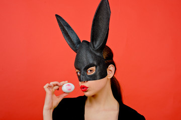 Easter woman. Woman rabbit, easter bunny girl. Red lip imprint on easter egg on red background....