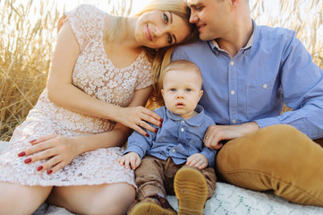 Mother, father and small boy sitting together outdoors