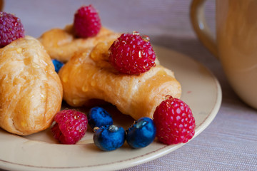 delicious summer juicy blueberry and raspberry berry with honey droplets on a fresh croissant