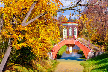 Fototapeta na wymiar Cross bridge in autumn foliage in Alexander park, Tsarskoe Selo (Pushkin), St. Petersburg, Russia