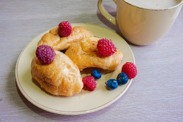 delicious summer juicy blueberry and raspberry berry with honey droplets on a fresh croissant