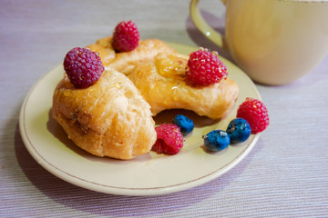 delicious summer juicy blueberry and raspberry berry with honey droplets on a fresh croissant