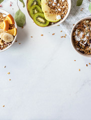 Healthy breakfast concept, cereal granola food with fruit in bowl organic muesli morning diet oat meal on white table, vegan background and detox snack for health nutrition vertical close up top view