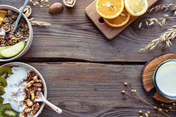 Fototapeta na wymiar Healthy breakfast concept, cereal granola food with fruit yogurt in bowl organic muesli and milk morning diet oat meal on brown wooden table background nut seed for health nutrition close up top view