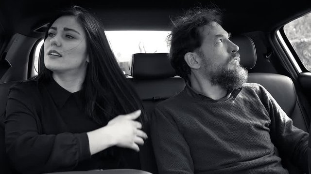 Couple fighting angry sitting in car unhappy black and white