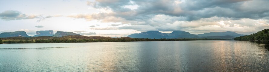 Panoramic view of sunrise over three small mountains. Canaima National Park, Venezuela