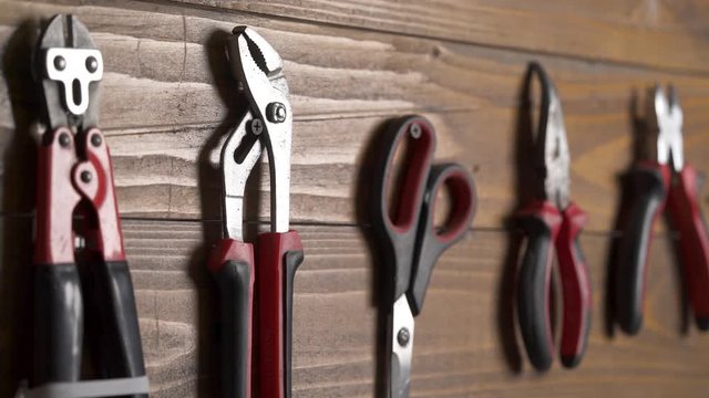 A set of craftsman hand tools. Male hand putting adjustable wrench on its place.