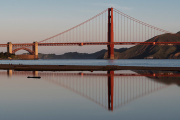 Early morning Golden Gate Bridge reflected in still water.