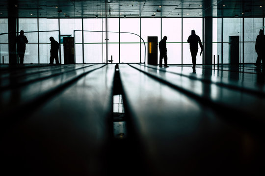 Street urban view with people reflected on the glass in the city unferground station or airport gate - job travel concept - desaturate gilter colors background