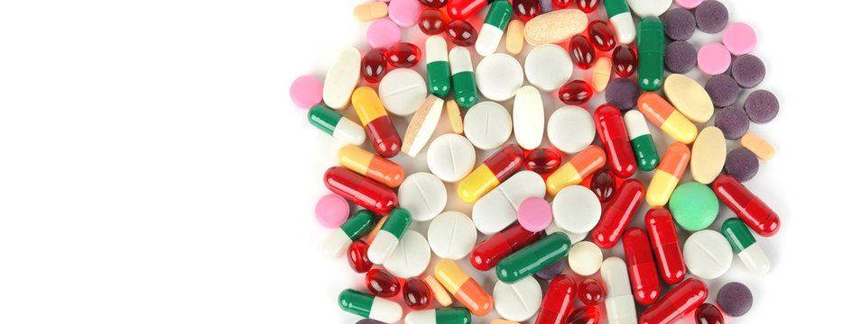 Сolorful pills on white background. Free space for text. Wide photo .