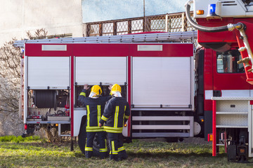firefighters at work with fire engine